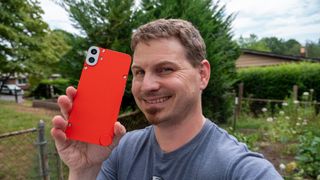 Holding the CMF Phone 1 with an orange back